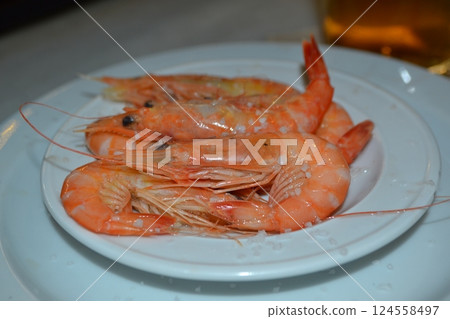 Delicious spanish seafood dish featuring fresh shrimp on a white plate. Spanish tapas Delicious spanish seafood dish featuring fresh shrimp on a white plate. Spanish tapas 124558497