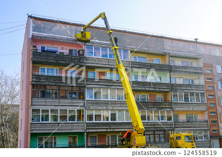 Sealing of seams in concrete panels of an apartment building using a telescopic boom lift platform Sealing of seams in concrete panels of an apartment building using a telescopic boom lift platform 124558519