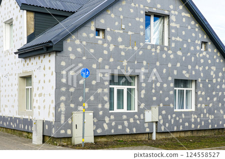 Thermal insulation of the facade of a residential building with thermal insulation material plates Thermal insulation of the facade of a residential building with thermal insulation material plates 124558527