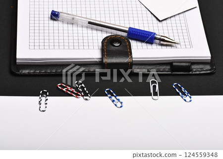 Organizer and pen on black and white background, close up Organizer and pen on black and white background, close up 124559348