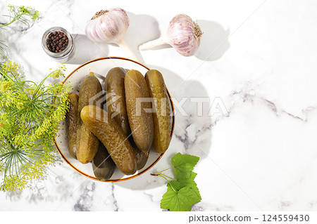 Fresh pickled cucumbers in a bowl with garlic and dill on a concrete table, village harvest, homemade pickling recipe, cucumbers and ingredients for pickling, home canning concept, Fresh pickled cucumbers in a bowl with garlic and dill on a concrete table, village harvest, homemade pickling recipe, cucumbers and ingredients for pickling, home canning concept, 124559430