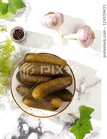 Fresh pickled cucumbers in a bowl with garlic and dill on a concrete table, village harvest, homemade pickling recipe, cucumbers and ingredients for pickling, home canning concept, Fresh pickled cucumbers in a bowl with garlic and dill on a concrete table, village harvest, homemade pickling recipe, cucumbers and ingredients for pickling, home canning concept, 124559431