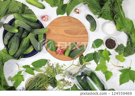 Cucumbers and ingredients for pickling them, home canning concept, Cucumbers, dill, garlic, currant leaves, cherries, horseradish, oak and basil, rustic pickling recipe, healthy and natural food. Cucumbers and ingredients for pickling them, home canning concept, Cucumbers, dill, garlic, currant leaves, cherries, horseradish, oak and basil, rustic pickling recipe, healthy and natural food. 124559469