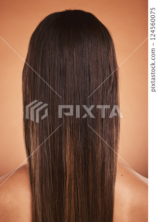 Beauty, hair care and woman with a balayage in a studio from the back with a beautiful hairstyle. Wellness, natural and model with long, straight and clean hair style isolated by a orange background. 124560075