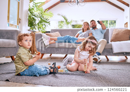 Parents on sofa, children play on floor in home and family time together on weekend morning in Dallas. Streaming movie, young kids bonding with toys and dad searching channel watching tv with mom Parents on sofa, children play on floor in home and family time together on weekend morning in Dallas. Streaming movie, young kids bonding with toys and dad searching channel watching tv with mom 124560221