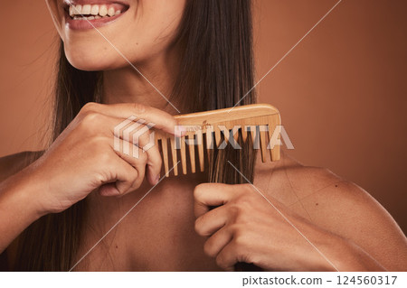 Woman combing hair, closeup smile and cosmetic face beauty for model with orange studio background. Hair care health, happy cosmetic girl and wood recycle comb for wellness with natural healthy locks 124560317