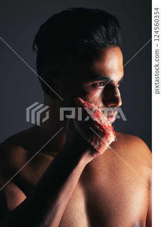 Fight, boxing and man with fist injury after training against black studio background. Violence, fitness and boxer, fighter or athlete with focus and hand with blood after accident in sports action 124560354