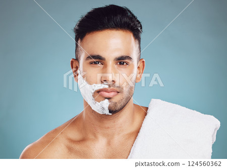 Shaving, beard and man with cream on his face for skincare against a blue mockup studio background. Wellness, health and portrait of a model with soap or foam to remove facial hair with mock up space 124560362