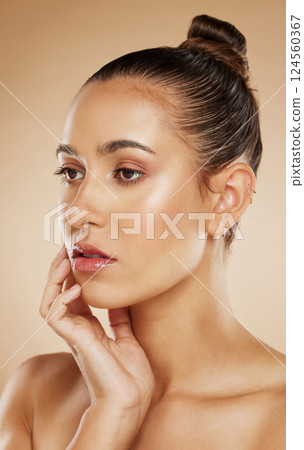 Beauty, natural and makeup girl thinking with healthy, radiant and cosmetic face touch. Attractive cosmetic model thoughtful feeling glowing skin with beige gradient studio background. 124560367