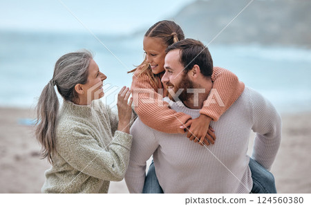 Family, love and piggy back at beach on holiday, vacation or trip. Support, care and grandma with father carrying girl outdoors, enjoying quality time together having fun or bonding by sandy seashore 124560380