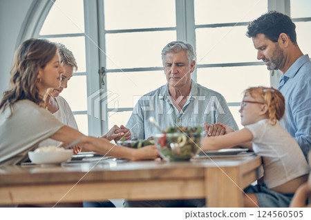 Big family, food and praying for gratitude and healthy lunch together while holding hands for love, religion and thanksgiving. Men, women and child together for healthy eating at home dining table 124560505