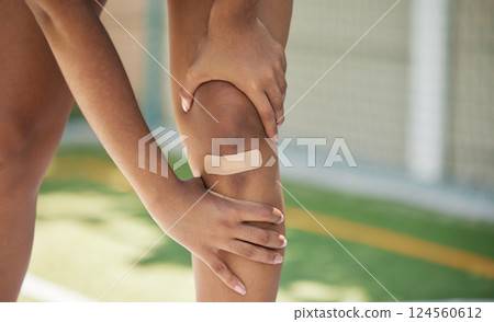 Woman athlete, knee pain and sport injury outdoor with bandaid with inflammation, joint and strain accident. Girl holding leg, muscles tear and joint swelling or muscle fatigue in sports competition Woman athlete, knee pain and sport injury outdoor with bandaid with inflammation, joint and strain accident. Girl holding leg, muscles tear and joint swelling or muscle fatigue in sports competition 124560612