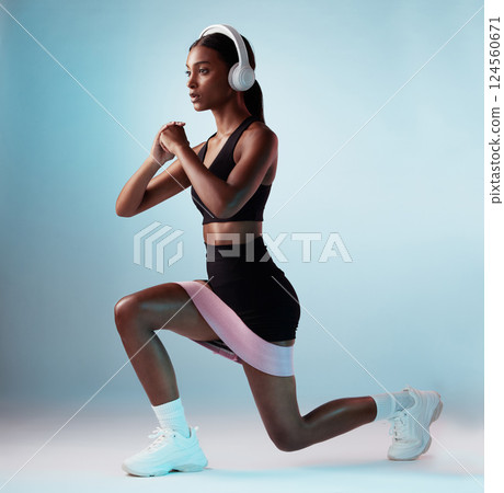 Woman, music headphones or resistance band workout on blue background in studio for training, exercise or gym. Personal trainer, person or fitness model with health goals, radio or motivation podcast 124560671