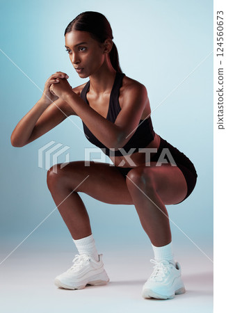 Woman, fitness squat or balance on blue background in studio for gym workout, training or exercise for strong muscles. Model, personal trainer or coach in wellness sports with health goals motivation 124560673
