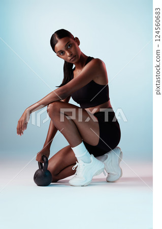 Woman, kettle bell or workout on blue background in studio for wellness, health or strong body muscles. Portrait, fitness model or sports athlete with heavy metal weights for gym training or exercise Woman, kettle bell or workout on blue background in studio for wellness, health or strong body muscles. Portrait, fitness model or sports athlete with heavy metal weights for gym training or exercise 124560683