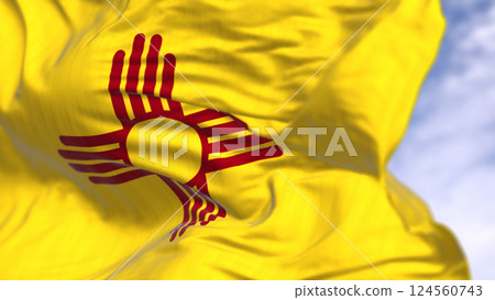 New Mexico state flag waving with red Zia sun symbol on yellow background New Mexico state flag waving with red Zia sun symbol on yellow background 124560743