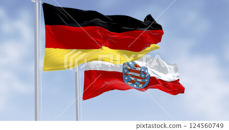 Flags of Germany and Thuringia waving together against blue sky, symbol of unity 124560749