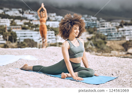 Yoga, fitness and beach with a black woman athlete on a rock by the ocean for a workout or exercise. Nature, summer and health with a happy female yogi training for wellness, zen or mental health Yoga, fitness and beach with a black woman athlete on a rock by the ocean for a workout or exercise. Nature, summer and health with a happy female yogi training for wellness, zen or mental health 124561069
