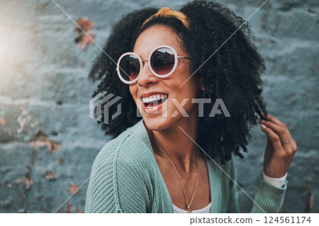 Fashion, summer and black woman in city with beauty, sunglasses and smile by blue brick wall. Travel, adventure and girl with trendy outfit having fun on weekend, holiday and vacation in urban town 124561174