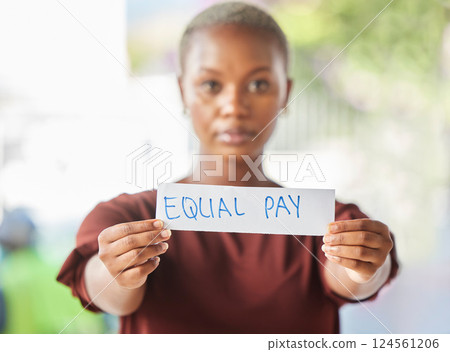 Equal pay, paper sign and black woman protest for women work salary rights outdoor. Portrait of a young person from Africa with serious protesting for female worker empowerment and equality Equal pay, paper sign and black woman protest for women work salary rights outdoor. Portrait of a young person from Africa with serious protesting for female worker empowerment and equality 124561206
