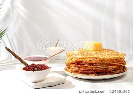 Delicious Russian pancakes with jam, soft cottage cheese and milk on a marble table. Healthy breakfast with ingredients, the concept of natural products and traditional national cuisine, advertising 124561255