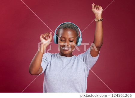 Music, dance and freedom with a black woman in studio on a red background for dancing or fun. Dancer, headphones and carefree with a young female streaming audio with an online service for enjoyment 124561266