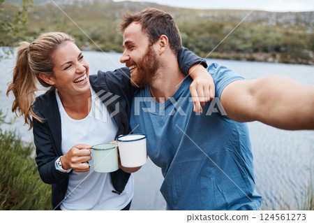 Selfie, coffee and couple by lake on vacation outdoors in nature, holiday or trip. Tea, relax and happy man and woman in love hug by river taking picture for happy memory or social media post online. Selfie, coffee and couple by lake on vacation outdoors in nature, holiday or trip. Tea, relax and happy man and woman in love hug by river taking picture for happy memory or social media post online. 124561273