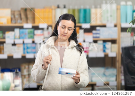 Woman choosing an ointment at the pharmacy Woman choosing an ointment at the pharmacy 124561297