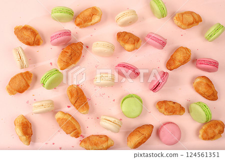 Fresh ruddy and colorful macaroons croissants on a light table with crumbs, Top view, place for text. Modern bakery concept, business card for advertising or invitation. Delicious traditional 124561351