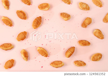 Fresh ruddy croissants on a light table with crumbs, top view, place for text. Modern bakery concept, business card for advertising or invitation. Delicious traditional breakfast, selective focus 124561352
