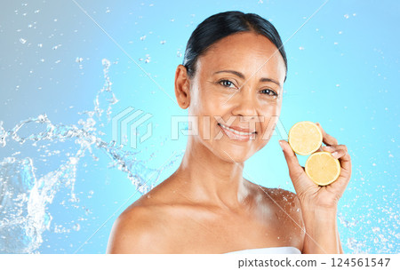 Lemon, skincare and beauty woman in studio mock up water splash for face, facial wellness and healthy glow portrait for advertising. Model with fruit for dermatology or vitamin c on blue mockup Lemon, skincare and beauty woman in studio mock up water splash for face, facial wellness and healthy glow portrait for advertising. Model with fruit for dermatology or vitamin c on blue mockup 124561547