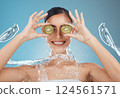Woman, shower and kiwi for beauty, skincare and eye treatment in a studio with mockup and blue background. Fruit, water and wellness girl model relax, happy and smile with organic, shower and product 124561571