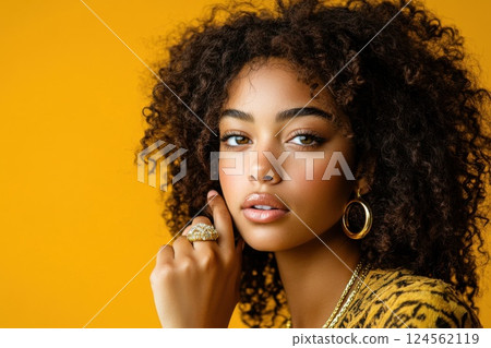 Model showcasing bold gold ring in minimalistic setting with soft lighting and striking expression 124562119