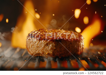 Juicy steak sizzling on grill with flames and smoke creating a vibrant cooking atmosphere 124562722