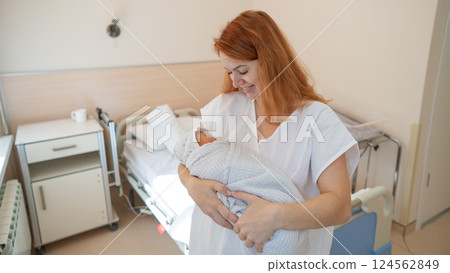 Caucasian woman holding newborn son in maternity hospital ward.  124562849