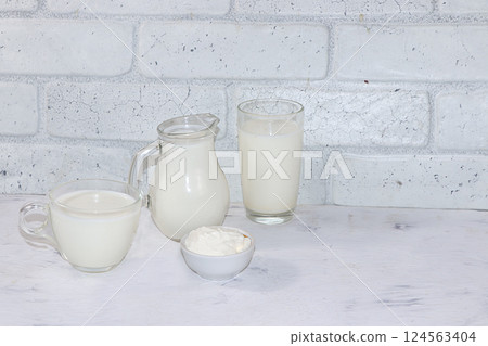 Fresh simple homemade kefir drink, milk and sour cream on a gray concrete background with copy space. Probiotic cold sour-milk drink, the concept of a healthy diet, maintaining a healthy intestinal 124563404