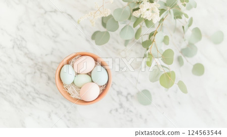 Minimalist Easter centerpiece featuring pastel Easter eggs on marble countertop with eucalyptus leaves for a stylish celebration 124563544