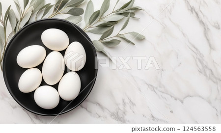 Elegant minimalist Easter centerpiece featuring white eggs and eucalyptus leaves on a marble countertop, perfect for spring celebrations and holiday gatherings with a modern twist 124563558