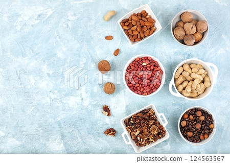Assortment of different nuts, healthy natural food concept, almonds, pecans, pistachios, cashews, walnuts and pine nuts, high-calorie food with vegetable protein and vitamins, dietary nutrition basis, 124563567