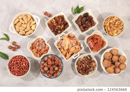 Assortment of various nuts and dried fruits, healthy natural food concept, almonds, nuts, pecans, pistachios, cashews, walnuts and pine nuts, apples, raisins, dried apricots, food with vegetable Assortment of various nuts and dried fruits, healthy natural food concept, almonds, nuts, pecans, pistachios, cashews, walnuts and pine nuts, apples, raisins, dried apricots, food with vegetable 124563666