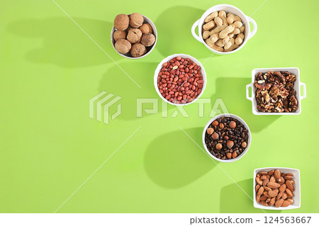 Assortment of assorted nuts with long shadows, healthy natural food concept, almonds, pecans, pistachios, cashews, walnuts and pine nuts, high calorie food with vegetable protein and vitamins, Assortment of assorted nuts with long shadows, healthy natural food concept, almonds, pecans, pistachios, cashews, walnuts and pine nuts, high calorie food with vegetable protein and vitamins, 124563667