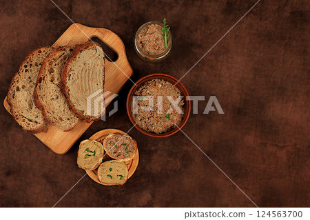 Homemade whole grain bread with chicken pate and arugula on a concrete background, the concept of a healthy lifestyle and natural nutrition. Healthy breakfast with ingredients, advertising for a cafe, 124563700