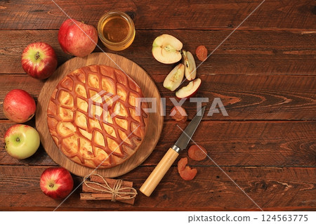 Kitchen background with apple pie, honey, apples, spices, cozy warm concept, hello autumn, hygge style, modern bakery advertisement, selective focus, top view, space for text, 124563775
