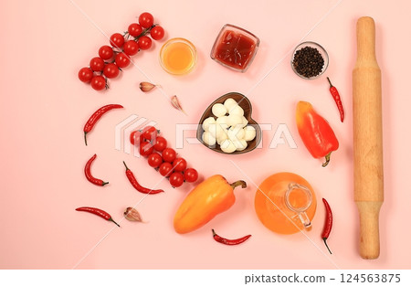 Pizza with ham, tomatoes, lemon, mozzarella, sauce, basil and cheese on a light background.Modern bakery concept, banner for menu or restaurant, top view, space for text. Selective focus 124563875