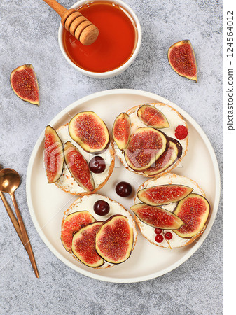 Ricotta,figs and bruschetta with honey on gray marble.Fresh sandwiches and toast with cream cheese,sliced figs,honey and cherries.Healthy breakfast with ingredients,lunch or dessert,diet food Ricotta,figs and bruschetta with honey on gray marble.Fresh sandwiches and toast with cream cheese,sliced figs,honey and cherries.Healthy breakfast with ingredients,lunch or dessert,diet food 124564012
