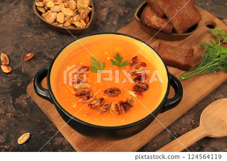 Pumpkin and zucchini cream soup with roasted seeds and toast,traditional autumn vegan food,healthy natural breakfast,advertising for cafe,restaurant,business card,selective focus 124564119