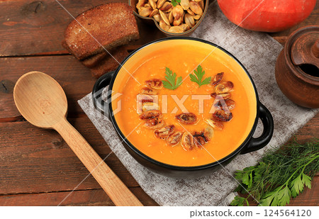 Pumpkin and zucchini cream soup with roasted seeds and toast,traditional autumn vegan food,healthy natural breakfast,advertising for cafe,restaurant,business card,selective focus 124564120