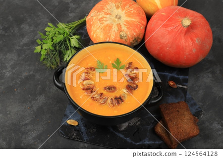 Pumpkin and zucchini cream soup with roasted seeds and toast in hollowed out pumpkin, traditional autumn halloween vegan food, baked in oven, healthy natural breakfast, advertisement for cafe, Pumpkin and zucchini cream soup with roasted seeds and toast in hollowed out pumpkin, traditional autumn halloween vegan food, baked in oven, healthy natural breakfast, advertisement for cafe, 124564128