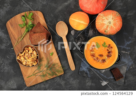 Pumpkin and zucchini cream soup with roasted seeds and toast,traditional autumn vegan food,healthy natural breakfast,advertising for cafe,restaurant,business card,selective focus 124564129