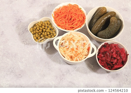 Fermented products on a concrete table, food background, advertising banner, healthy food concept, sauerkraut, kimchi, pickled beets, cucumbers, peas, olives, natural products for weight loss, top 124564210